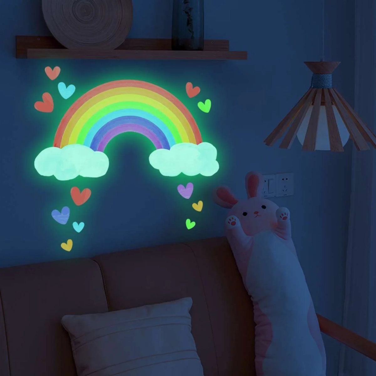 8 DIY Playroom Wall Art Ideas: Projects Kids Help Build 7 Glowing rainbow wall decals with clouds and hearts on a dark blue wall above a sofa.