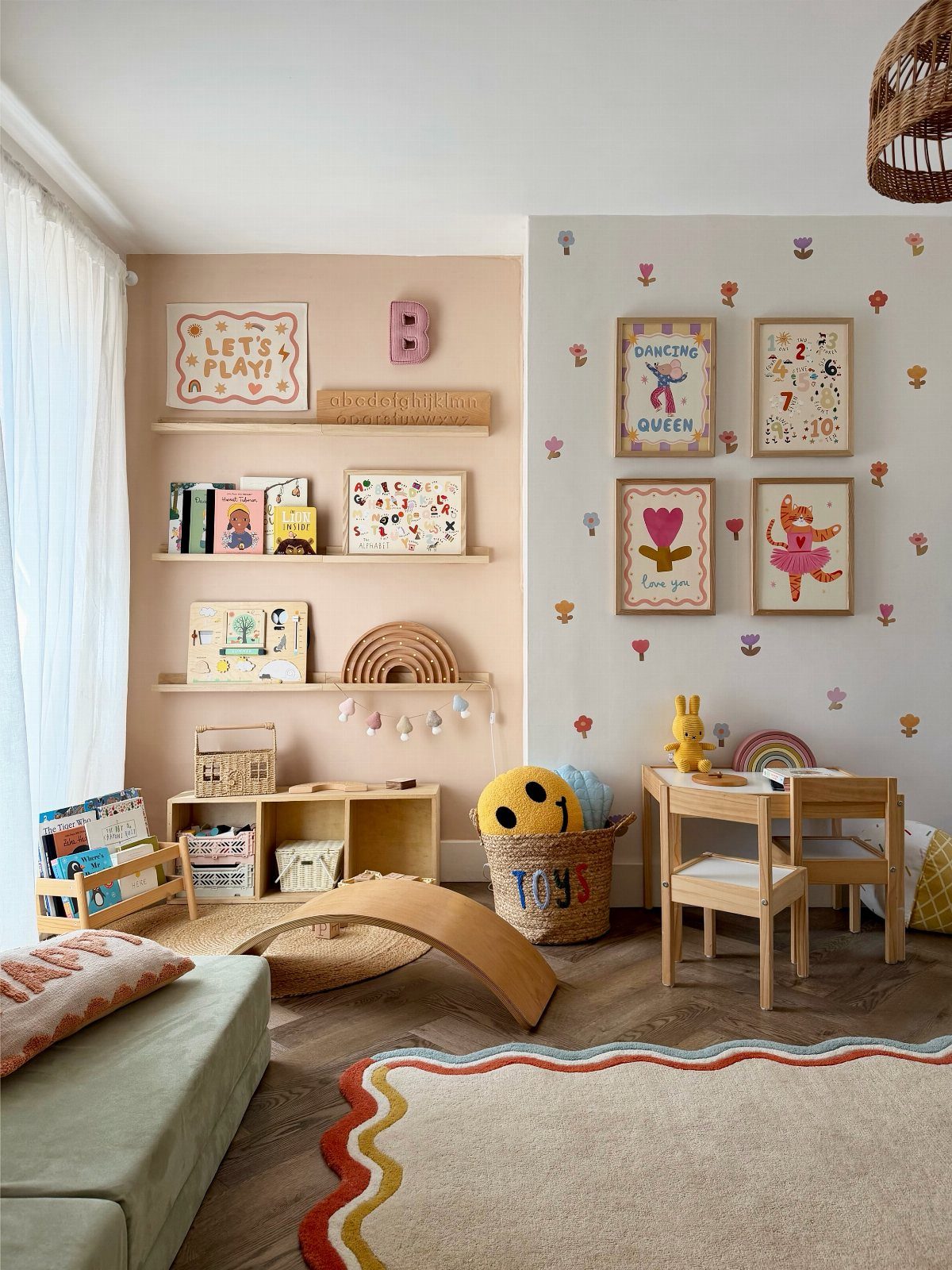 8 DIY Playroom Wall Art Ideas: Projects Kids Help Build 2 Children's playroom with wooden furniture, colorful wall decals, and framed art on shelves and walls.