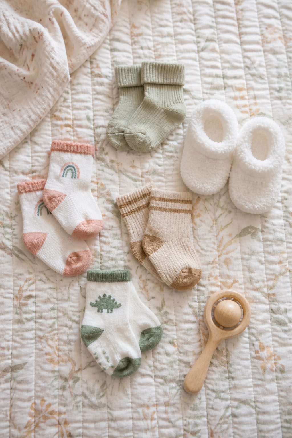 A variety of newborn socks and booties arranged together.