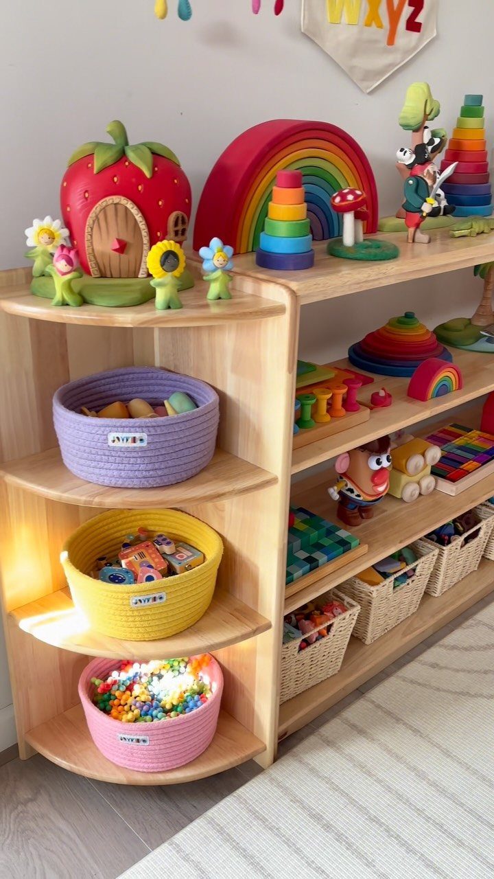 Light wood open shelves filled with colorful toys and various colored woven storage baskets.