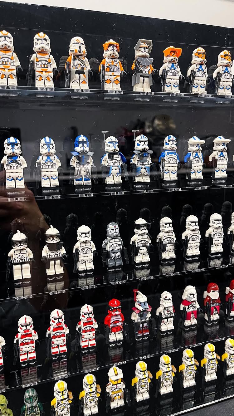 Multiple rows of LEGO Star Wars minifigures displayed on transparent shelves in a black case.