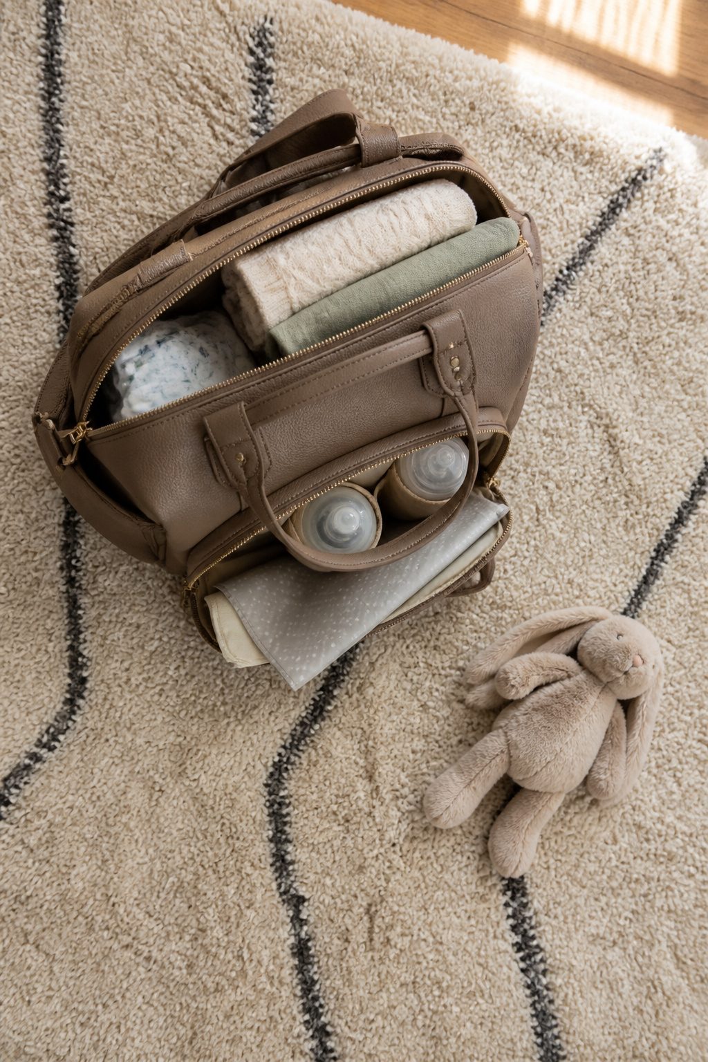 Diaper bag packed for winter outings, featuring insulated pockets.