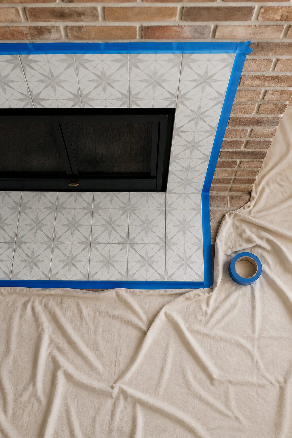 Tape applied along the edge of fireplace tiles and surrounding areas.