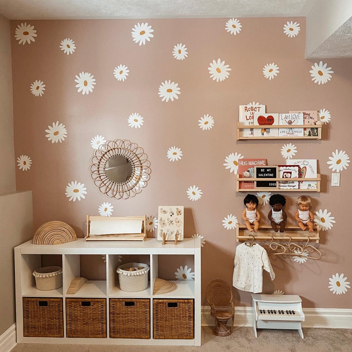 White daisy wall decals on a dusty rose wall in a child's playroom.