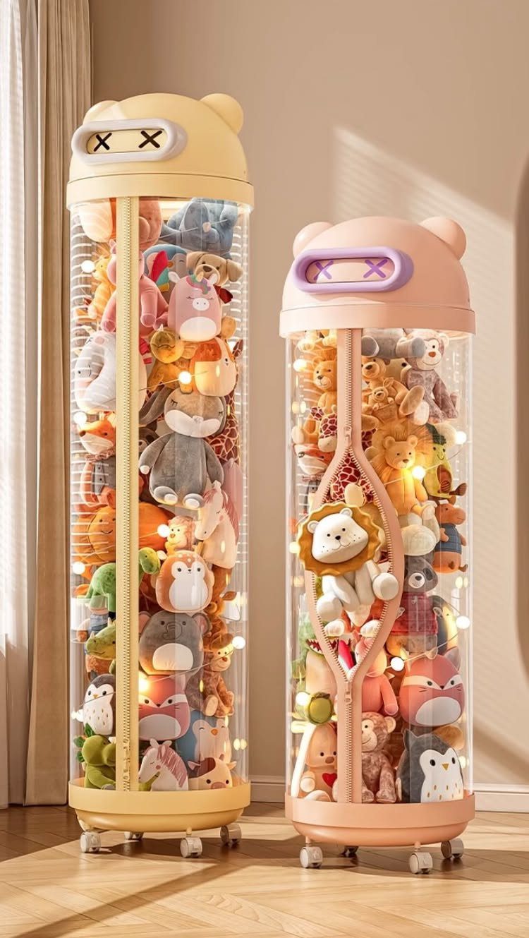 6 Plush Storage Ideas for Stuffed Toys That Clear Floor Pile-Ups 6 Two illuminated cylindrical clear plastic containers filled with colorful stuffed animals on wheels.