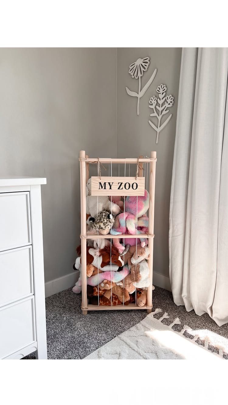 6 Plush Storage Ideas for Stuffed Toys That Clear Floor Pile-Ups 2 A wooden stuffed animal zoo enclosure filled with many colorful plush toys in a room.
