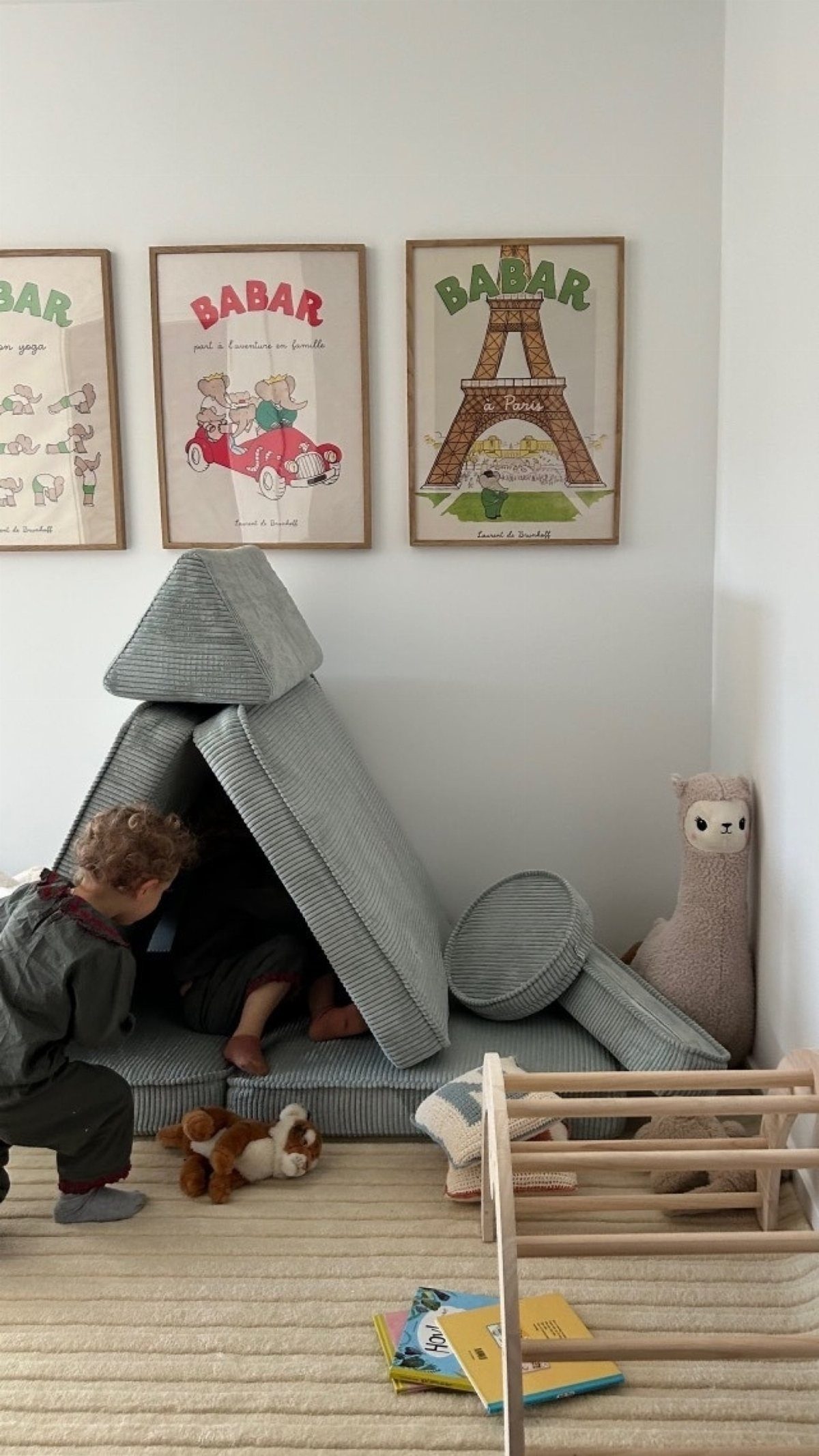 9 Small Play Area Ideas for Families Short on Space 9 A child playing inside a grey modular foam play tent in a bright room.