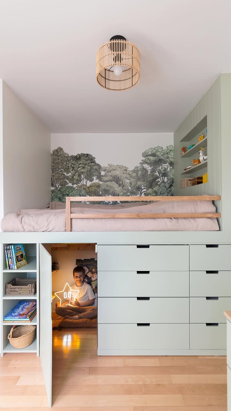 23 Small Playroom Design Ideas That Fit Real Rooms 23 A light green loft bed with a forest mural above and storage drawers below.