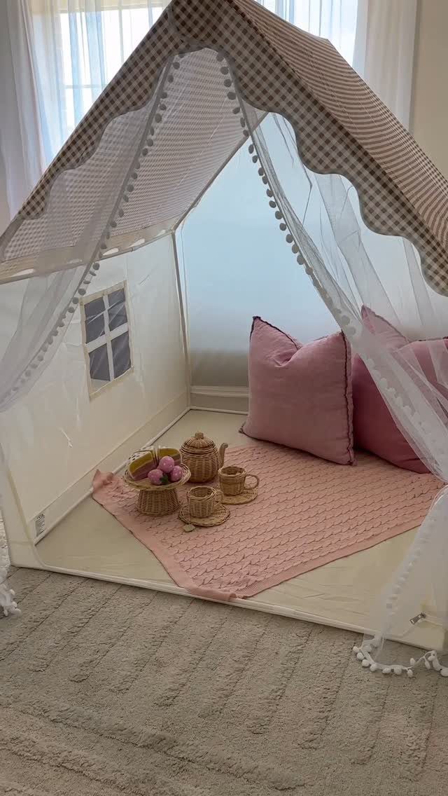 23 Small Playroom Design Ideas That Fit Real Rooms 21 A white fabric play tent with pink pillows and a tea set inside.