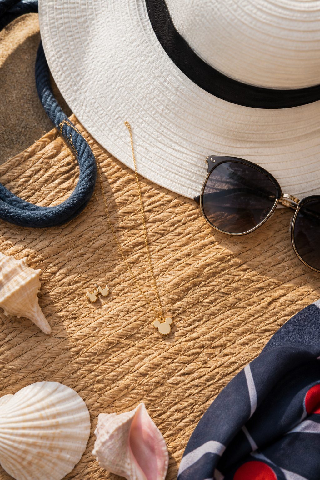 What to Wear on a Disney Cruise: 8 Outfit Types for 2026 6 Wide-brim hat, sunglasses, and minimal Disney-themed jewelry on display.